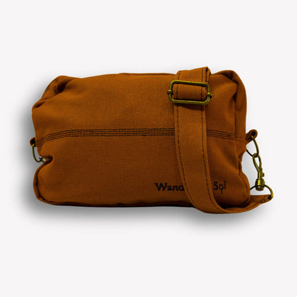Front view of Clay Brown Crossbody Bag by Wandering Sol showing hardware bronze detail  – made from recycled canvas with removable strap, can be worn as a clutch or shoulder bag.