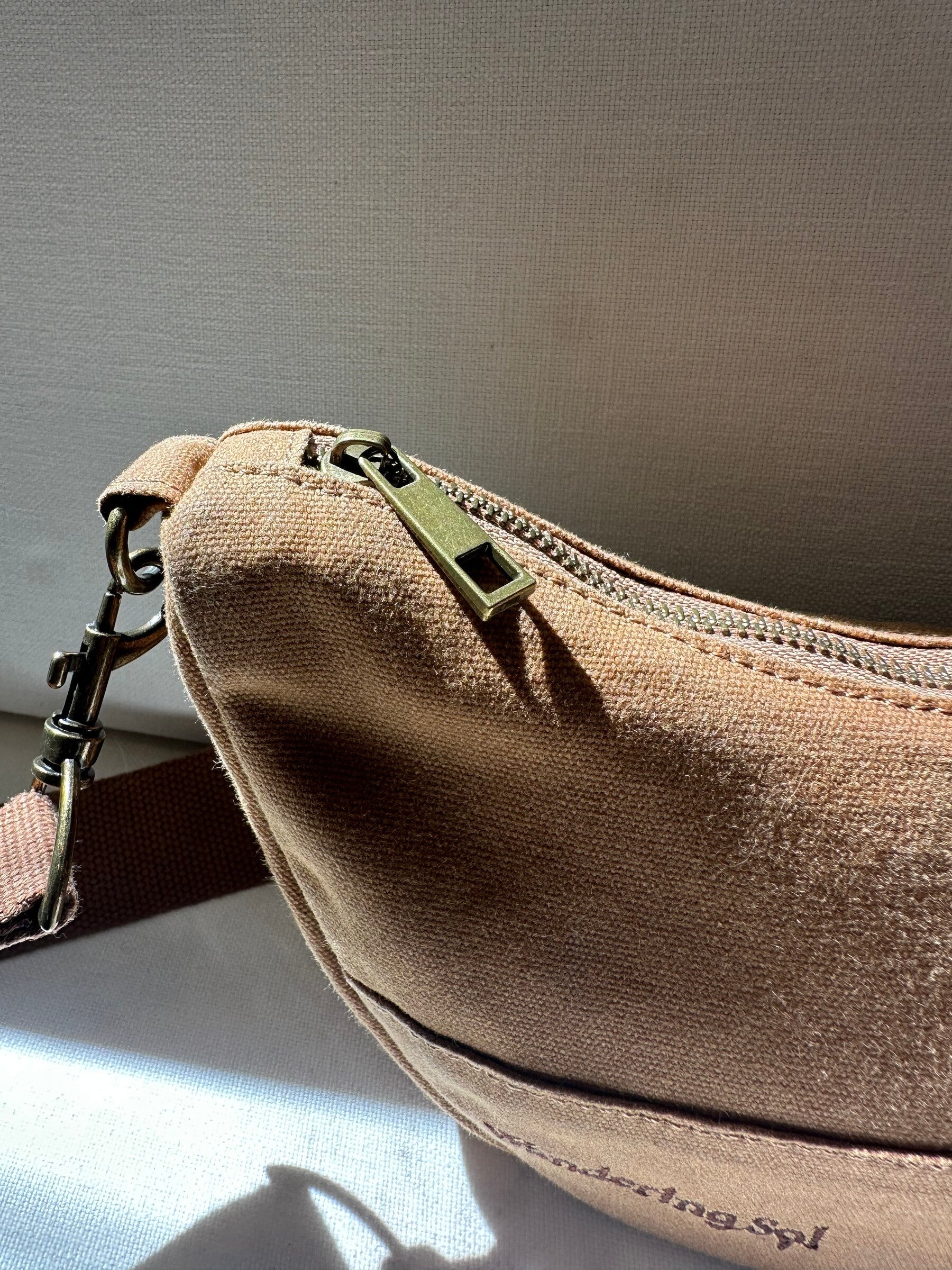 Close-up of the Crossbody zip and antique-brass-finish hardware