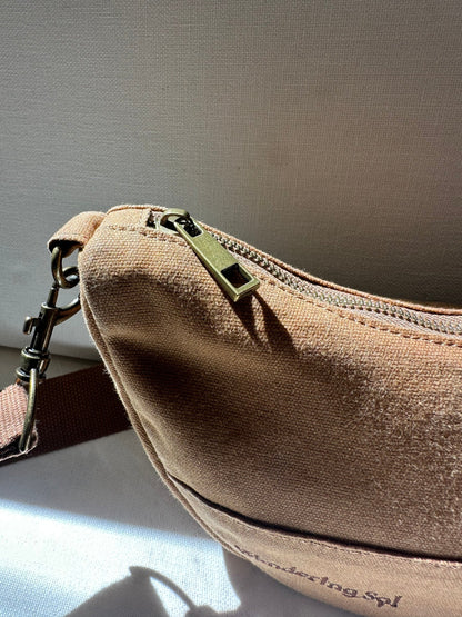 Close-up of the Crossbody zip and antique-brass-finish hardware